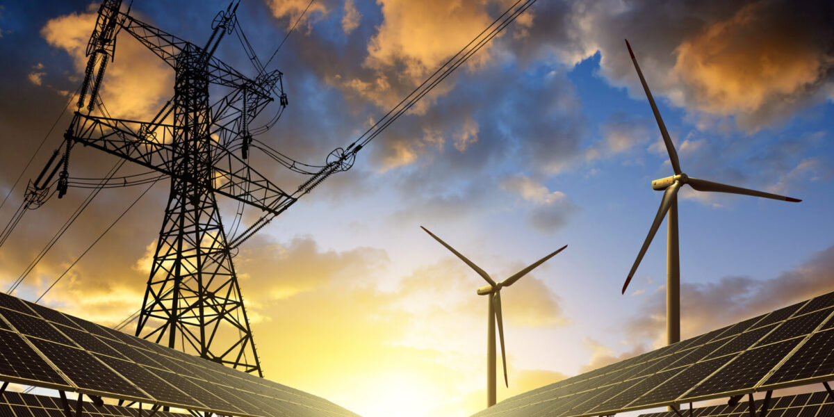 Un paisaje con paneles solares y aerogeneradores sobre campos de hierba, con un espectacular atardecer como fondo. A la izquierda, una torre de transmisión se alza, con líneas eléctricas que se extienden hacia el cielo. La escena simboliza las fuentes de energía renovables.